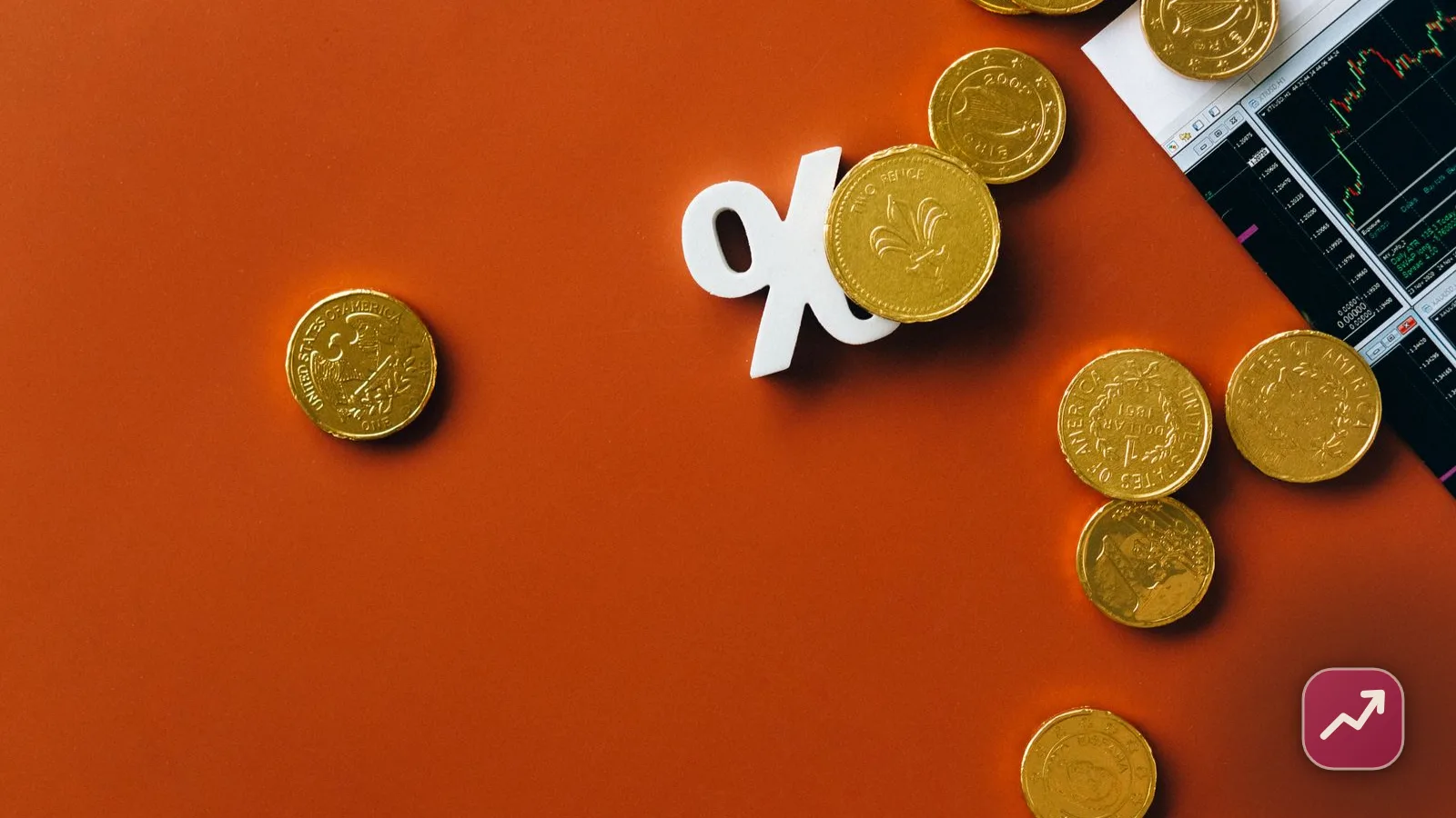 A white percent symbol among gold coins beside a stock market chart, illustrating how interest rates set the cost of borrowing and the return on savings.